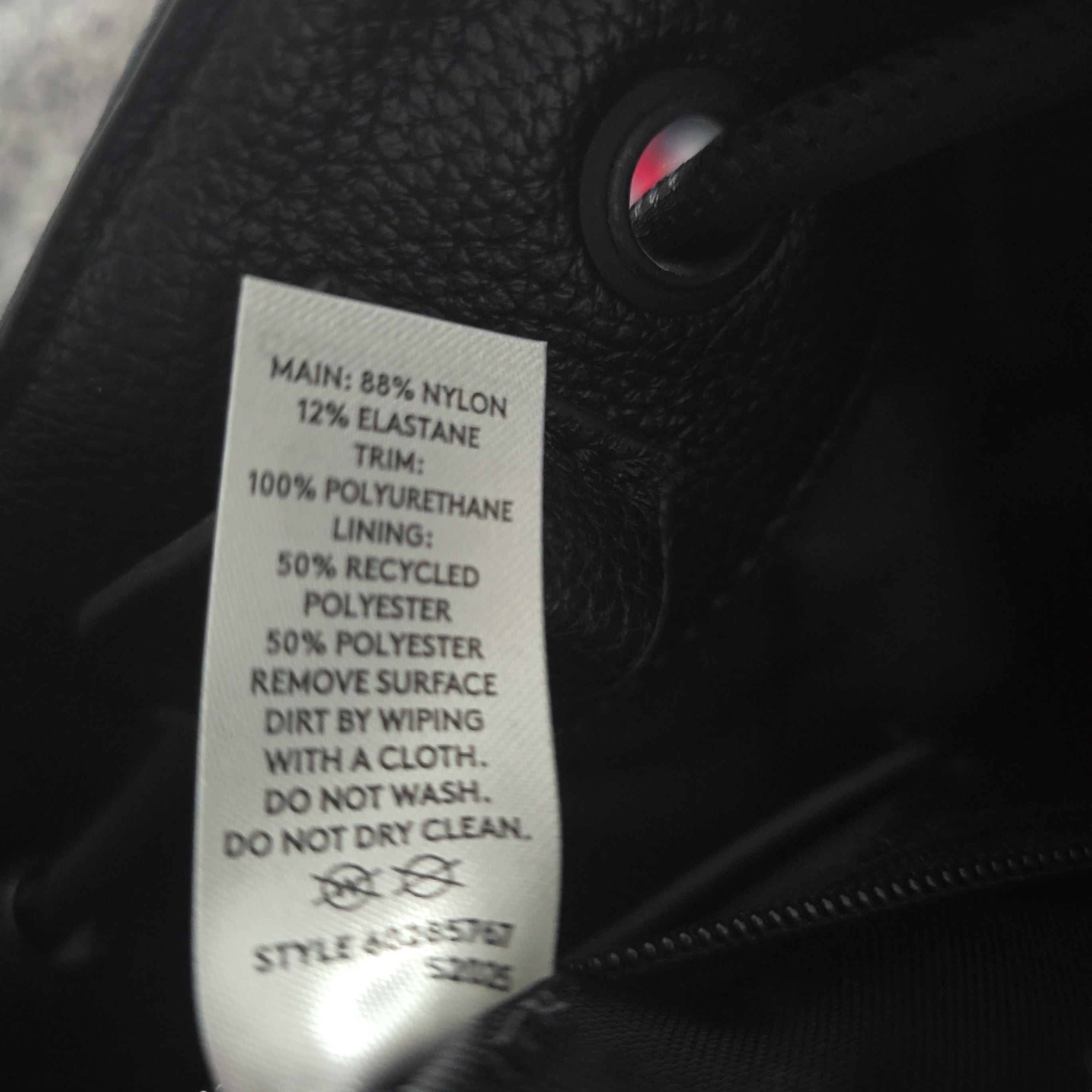 Close-up of a label on a black bag with text details.
