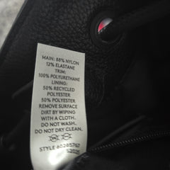 Close-up of a label on a black bag with text details.