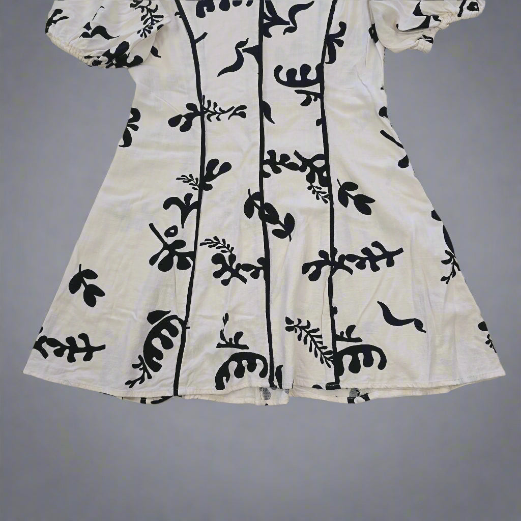 White fabric with black floral patterns on a tiled floor
