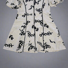 White fabric with black floral patterns on a tiled floor