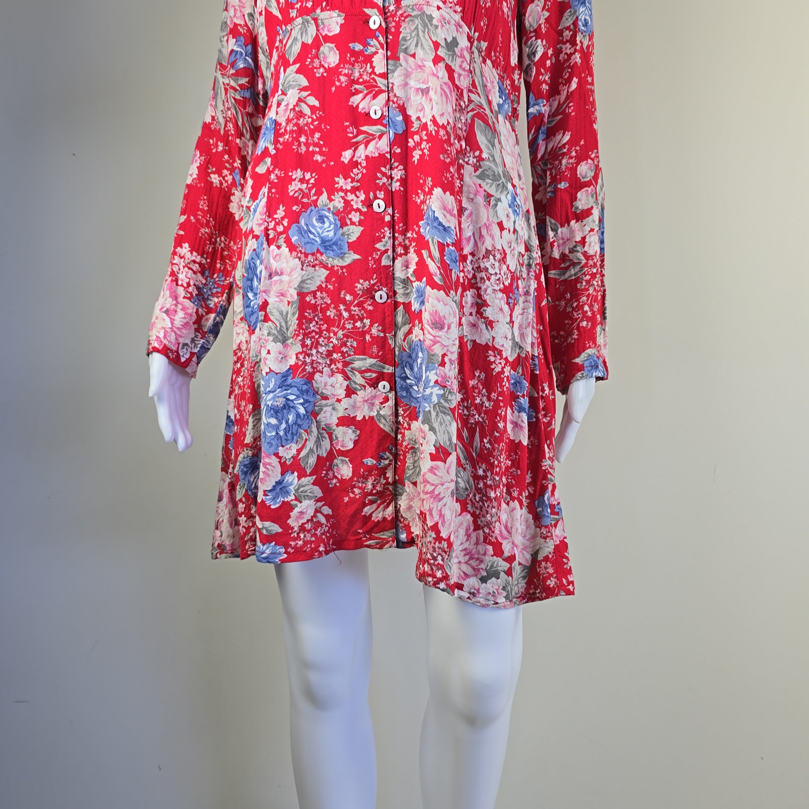 Red floral dress on a mannequin against a plain background