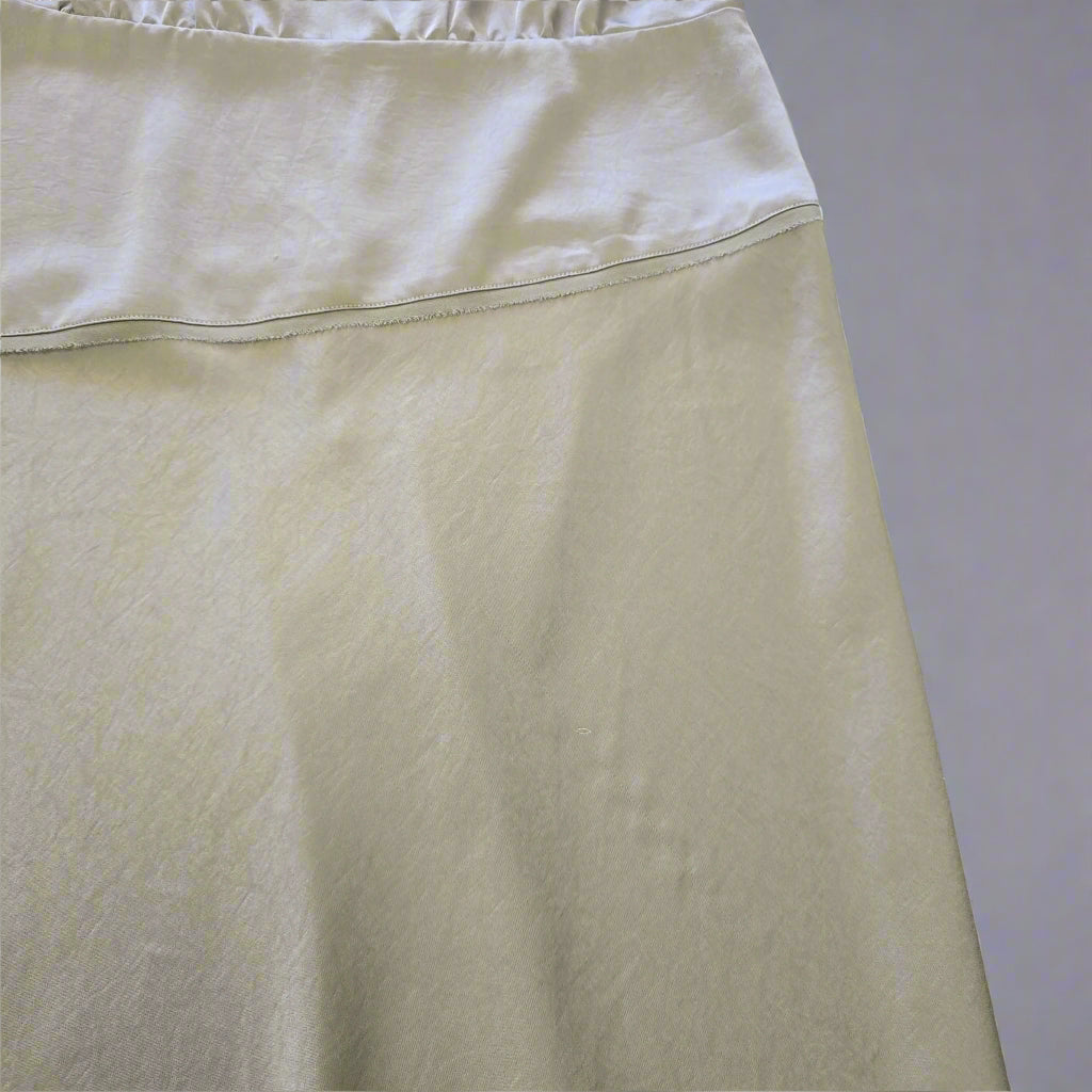 green fabric with a subtle pattern on a tiled floor background