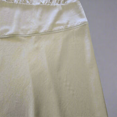 green fabric with a subtle pattern on a tiled floor background