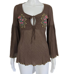 Brown top with floral embroidery on a mannequin against a white background