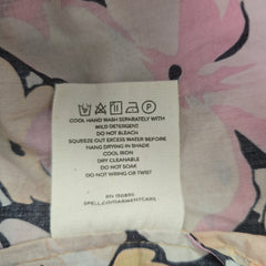 Clothing label on a floral-patterned fabric background