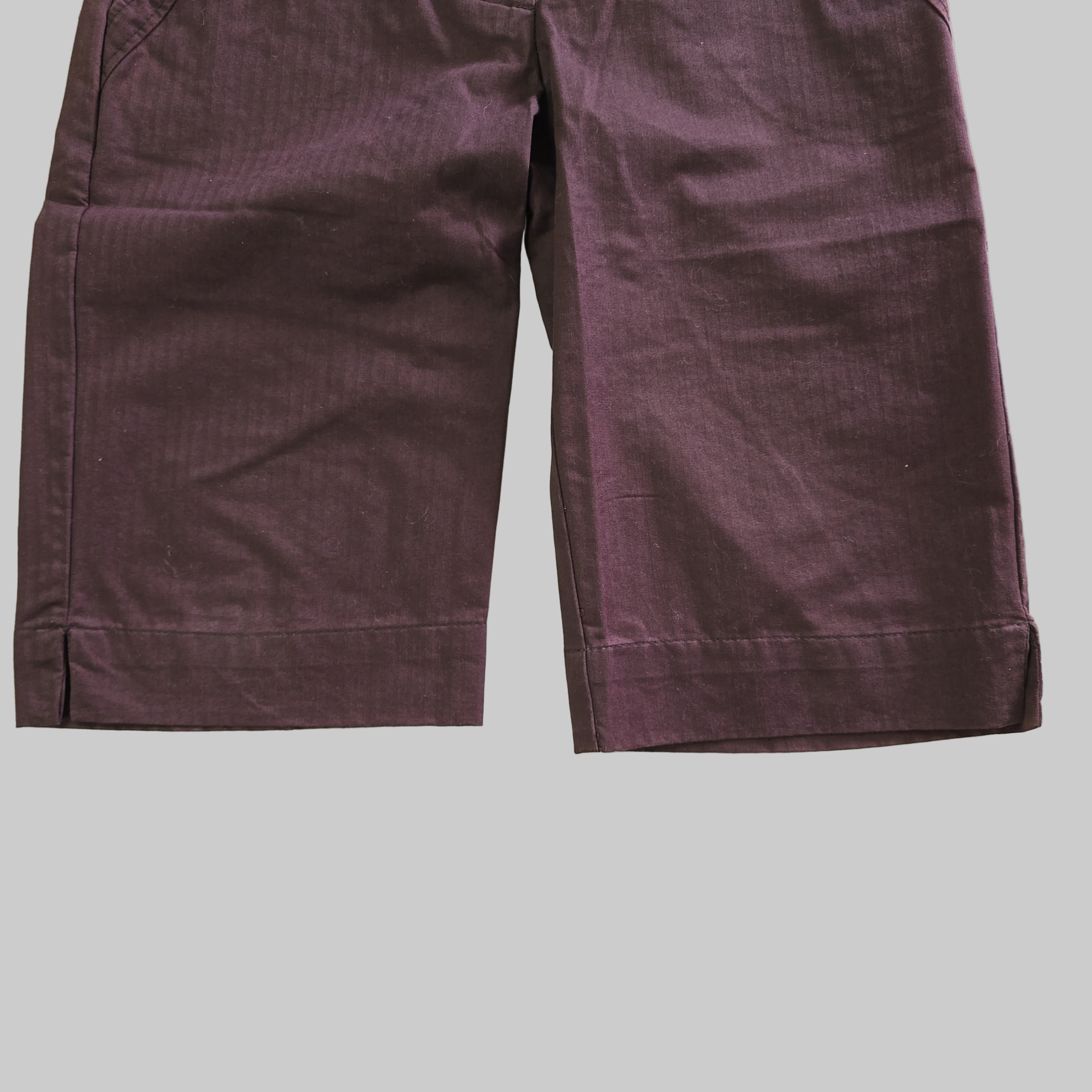 Folded purple pants on a tiled floor