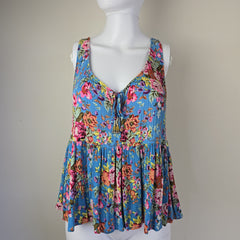 Colorful floral pleated top on a mannequin against a plain background