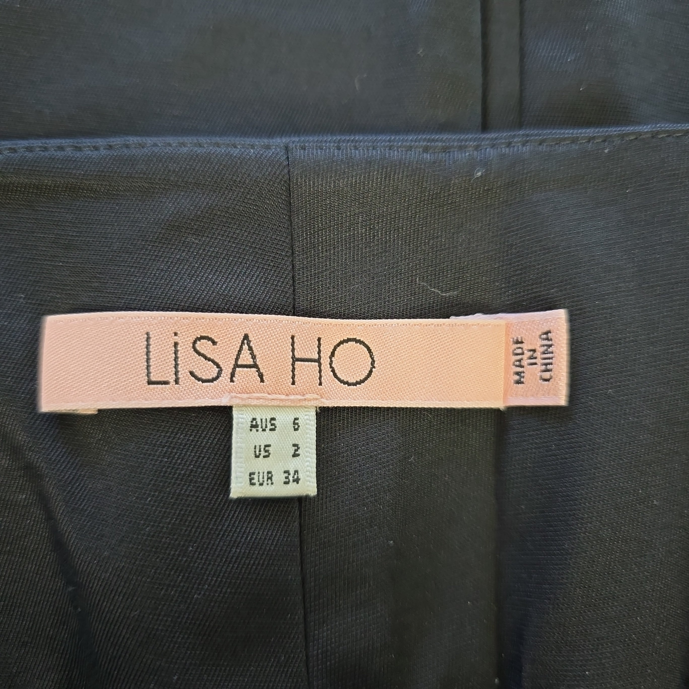 Label with 'LISA HO' on a dark fabric background