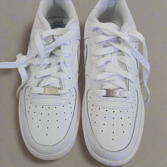 White sneakers with laces on a light gray surface