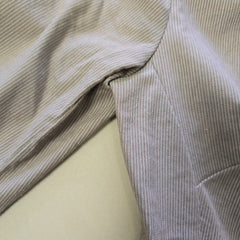 Close-up of beige fabric with subtle pattern on a light background