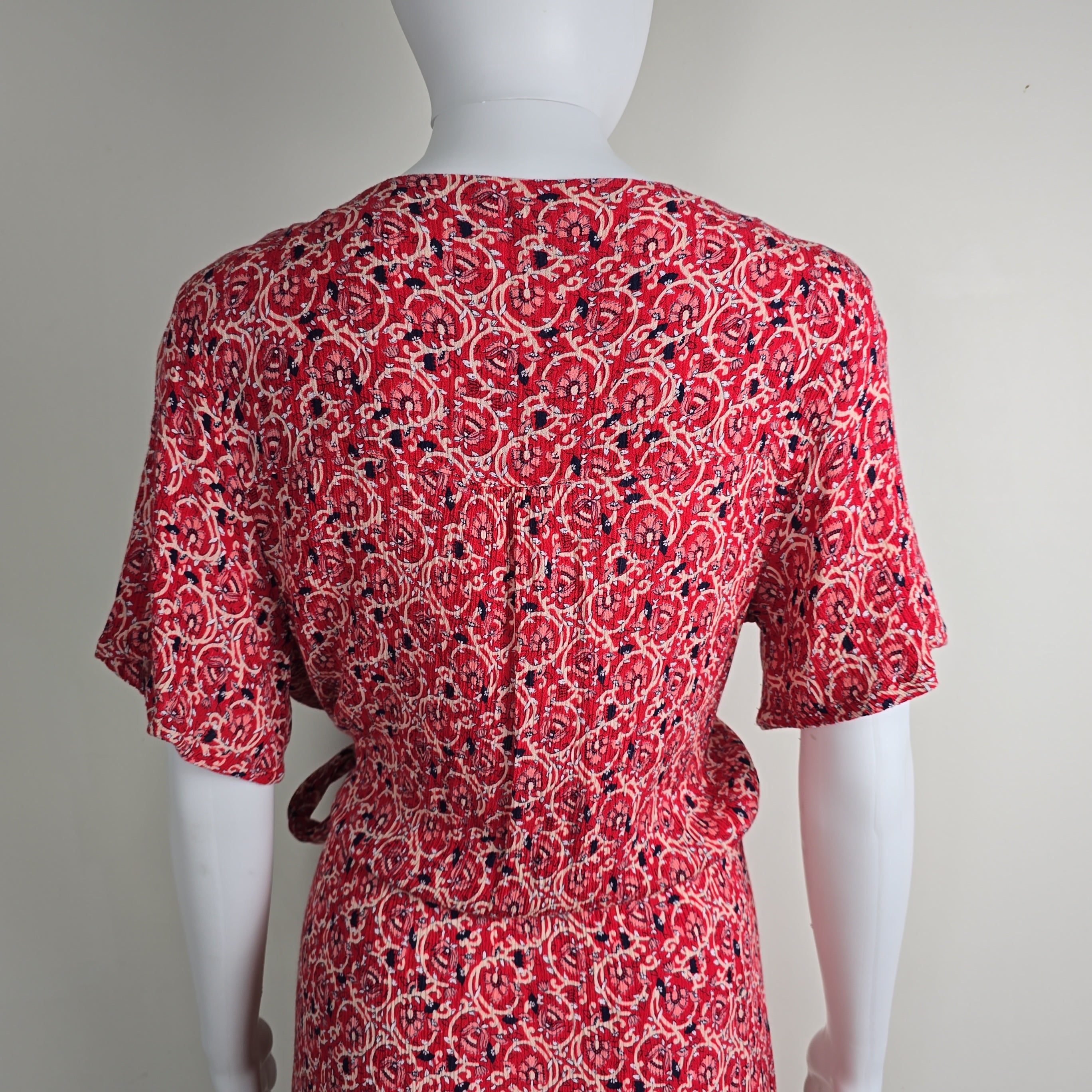 Red patterned garment on a mannequin against a plain background