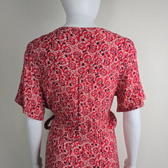 Red patterned garment on a mannequin against a plain background
