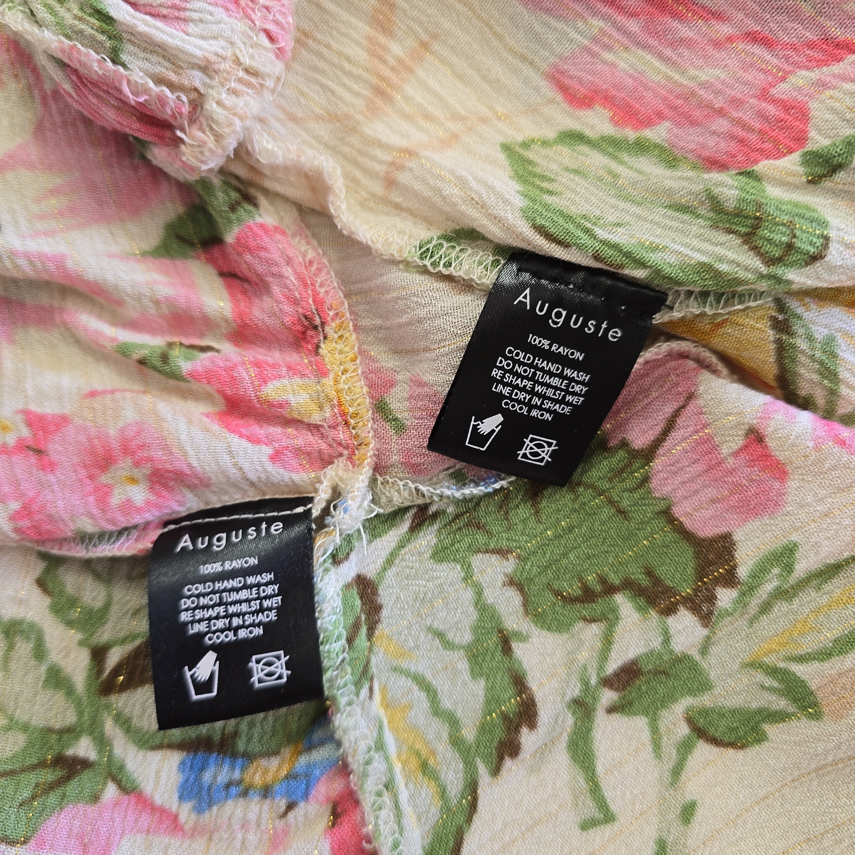 Floral fabric with Auguste labels on a close-up of the material.