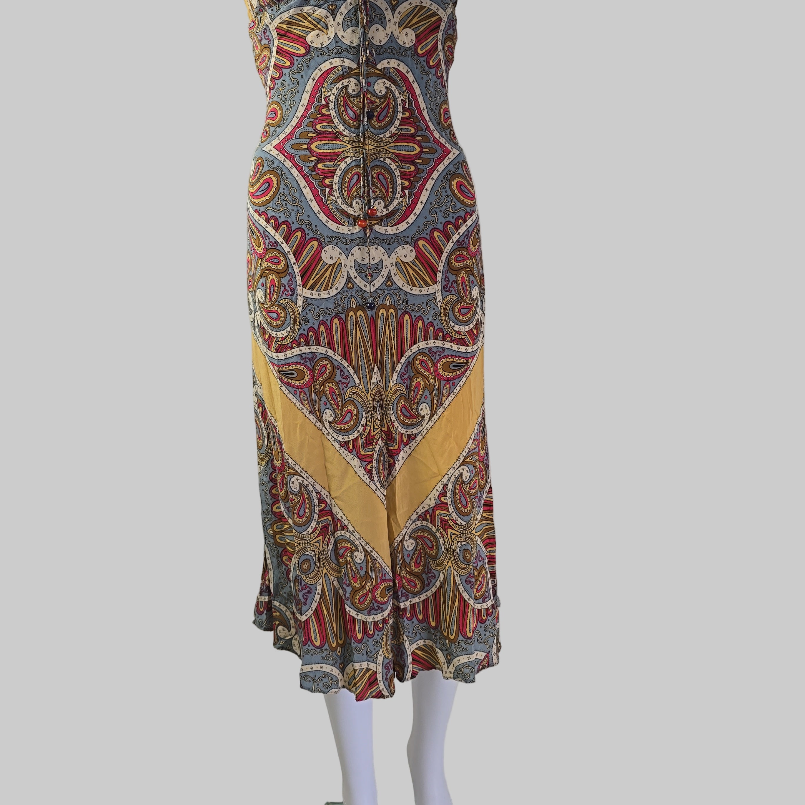 Colorful patterned fabric on a white mannequin arm against a neutral background