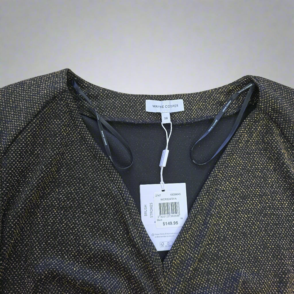 Black and gold dress with tags on a light background