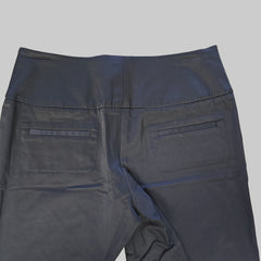 Black pants laid flat on a light-colored floor.