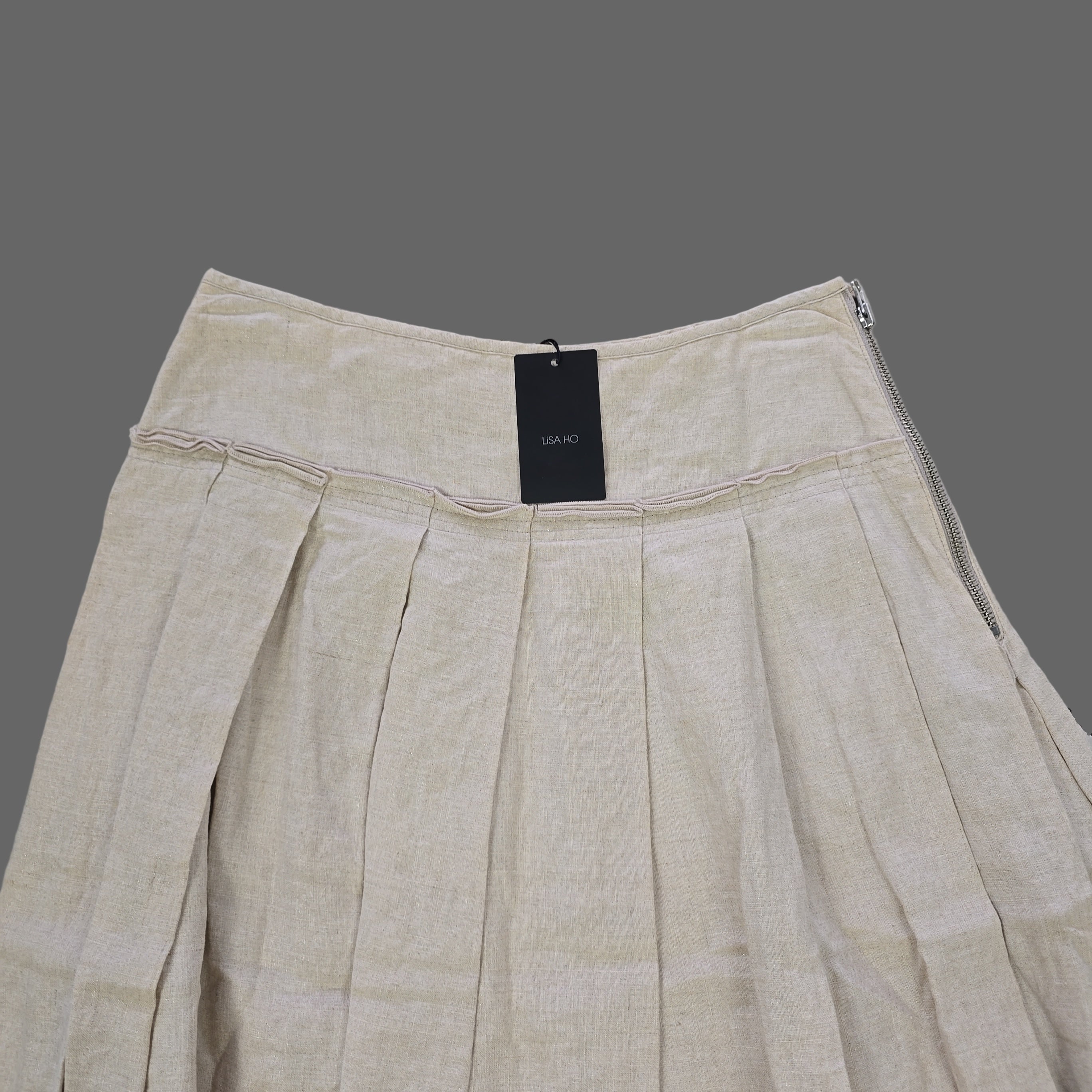 Beige skirt with a tag on a tiled floor