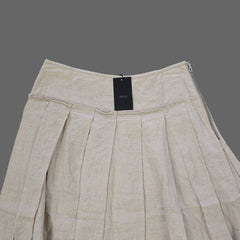 Beige skirt with a tag on a tiled floor
