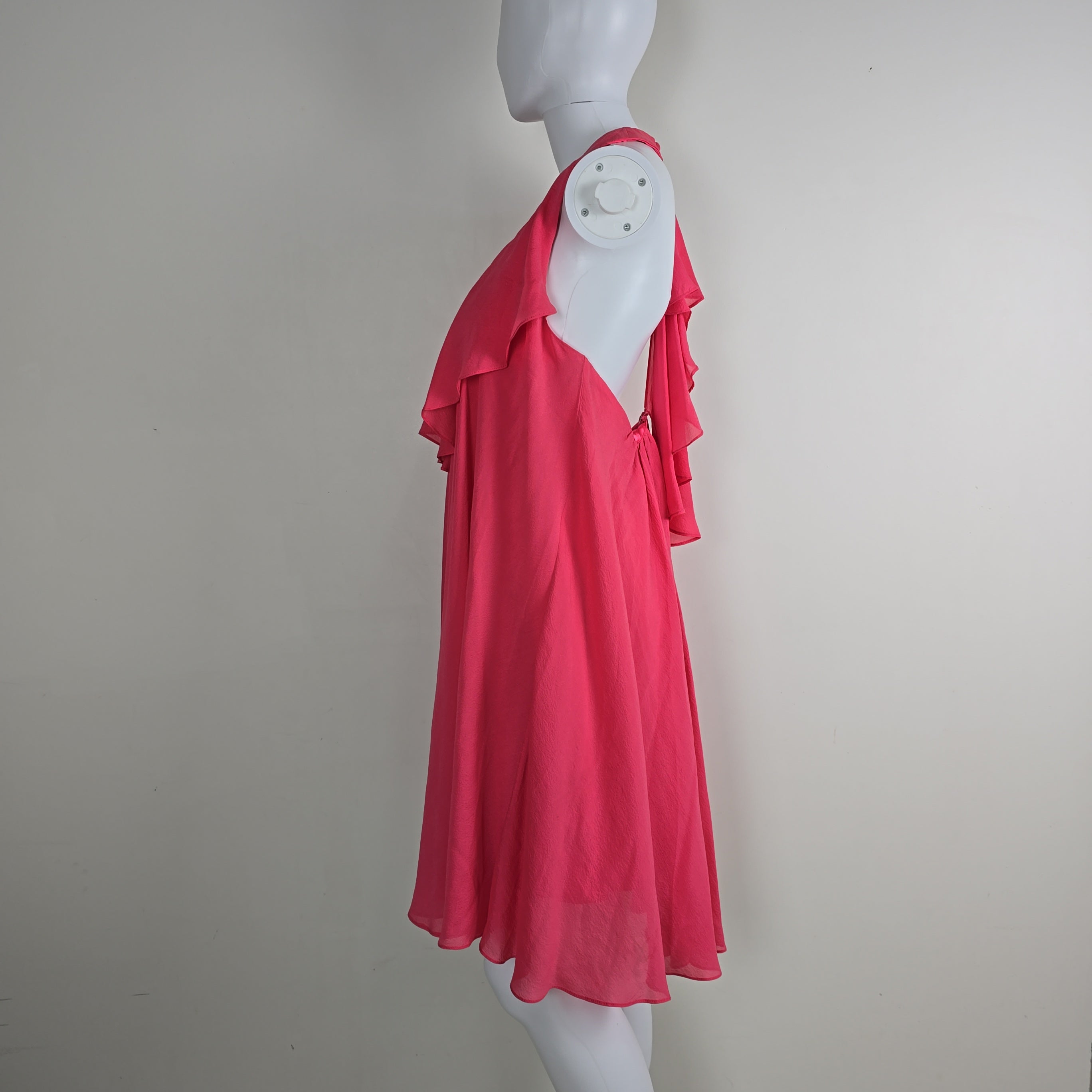Mannequin wearing a bright pink dress against a plain background