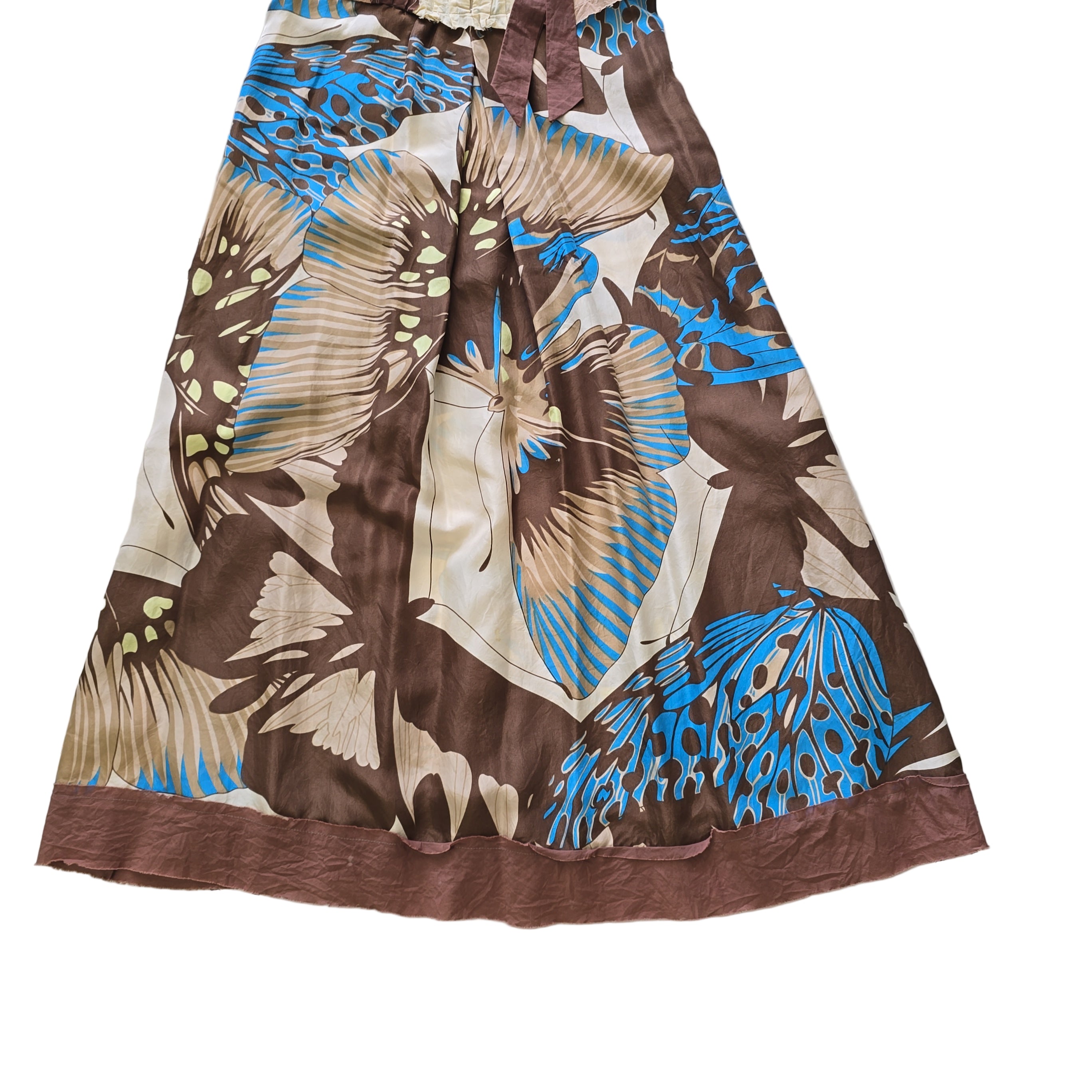 Brown fabric with blue and beige butterfly patterns on a tiled floor