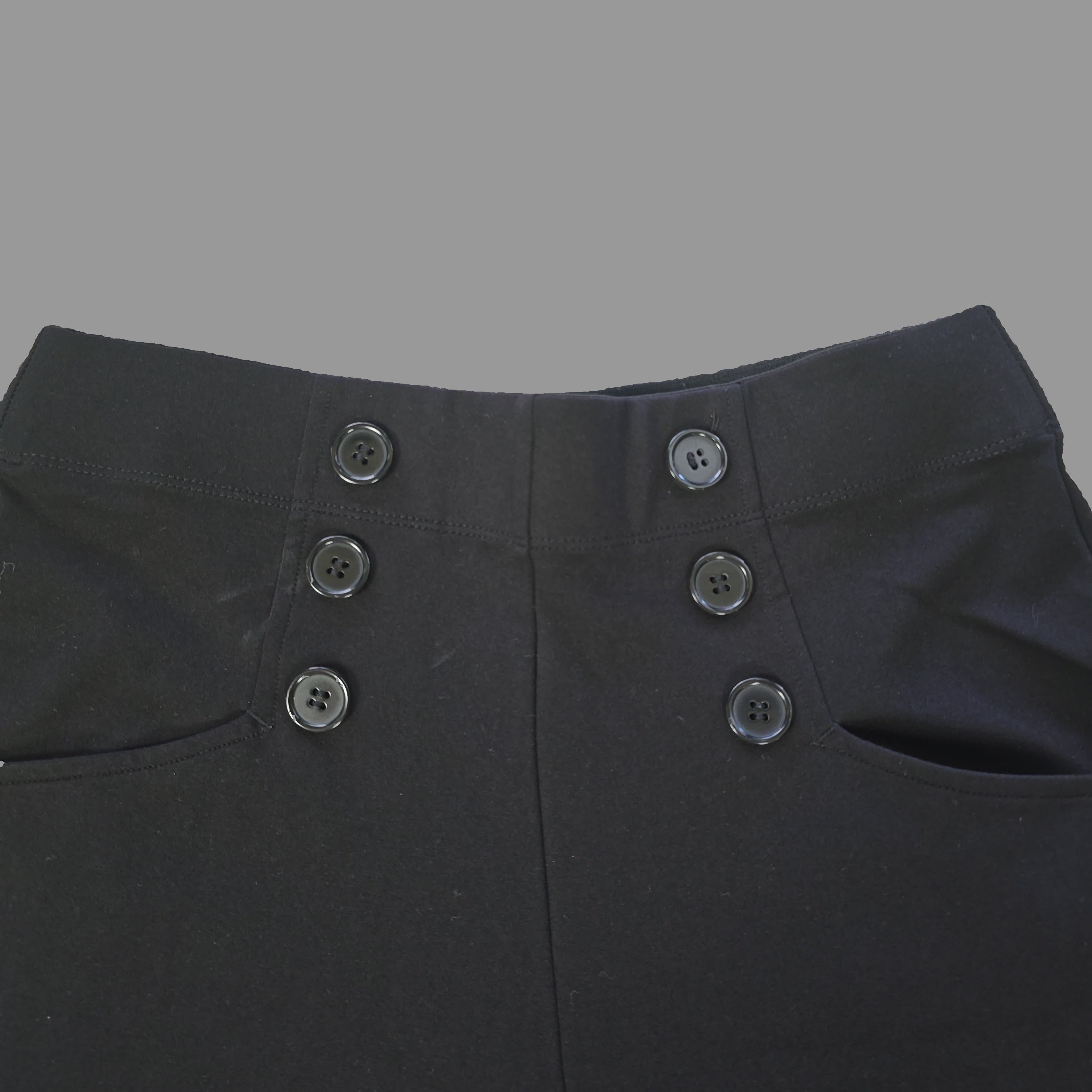 Close-up of black pants with buttons on a light background