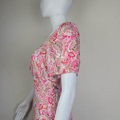 Mannequin wearing a pink paisley patterned garment against a plain background