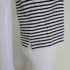 Mannequin wearing a black and white striped garment on a plain background