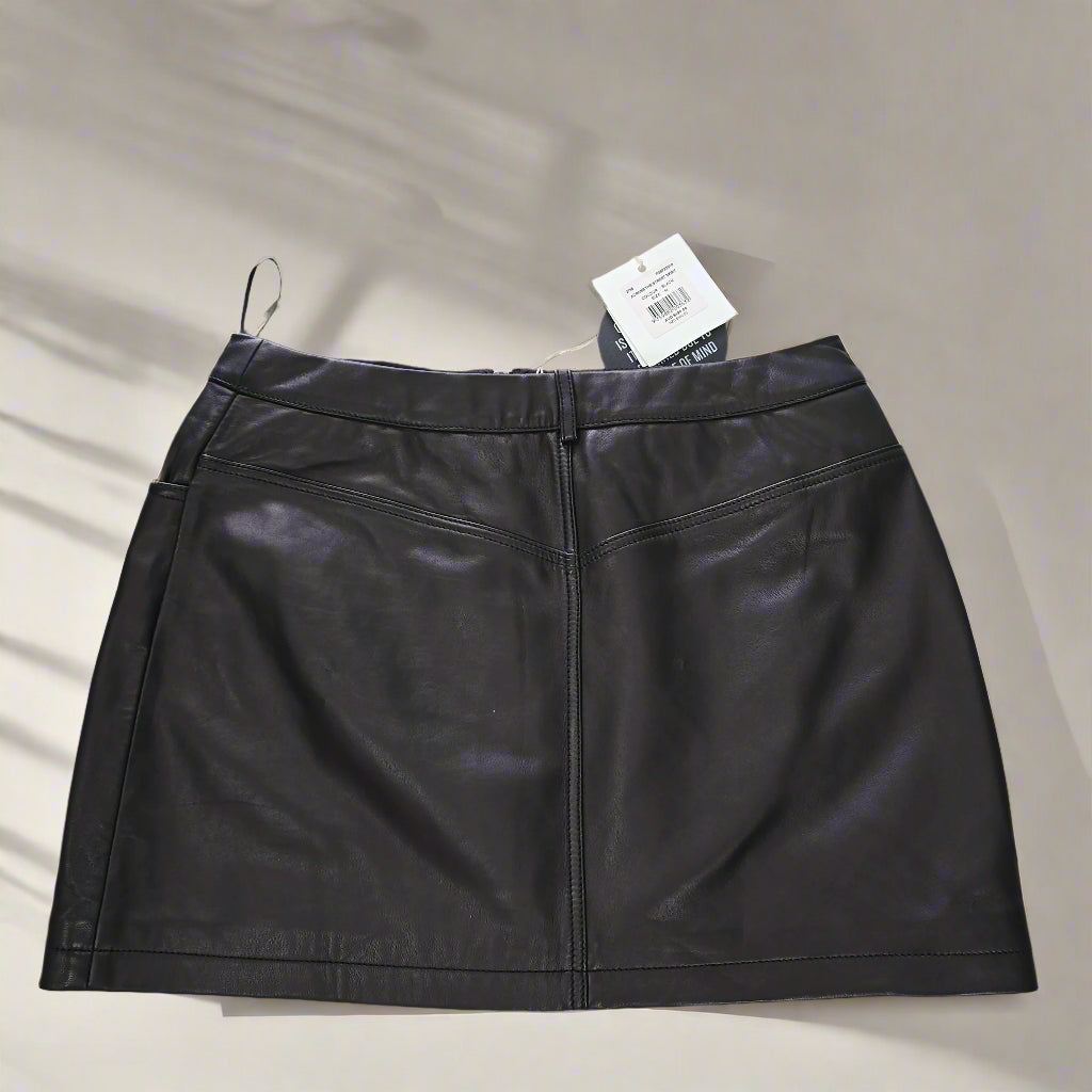 Black leather skirt with a tag on a tiled floor