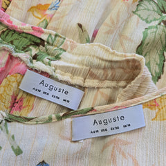 Floral fabric with 'Auguste' labels on a textured background
