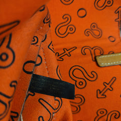 Close-up of an orange bag with black patterns and a visible brand tag.