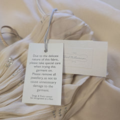 Fabric with care tag and warning label on a beige fabric background
