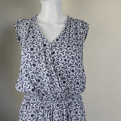 White mannequin wearing a blue and white patterned dress against a plain background