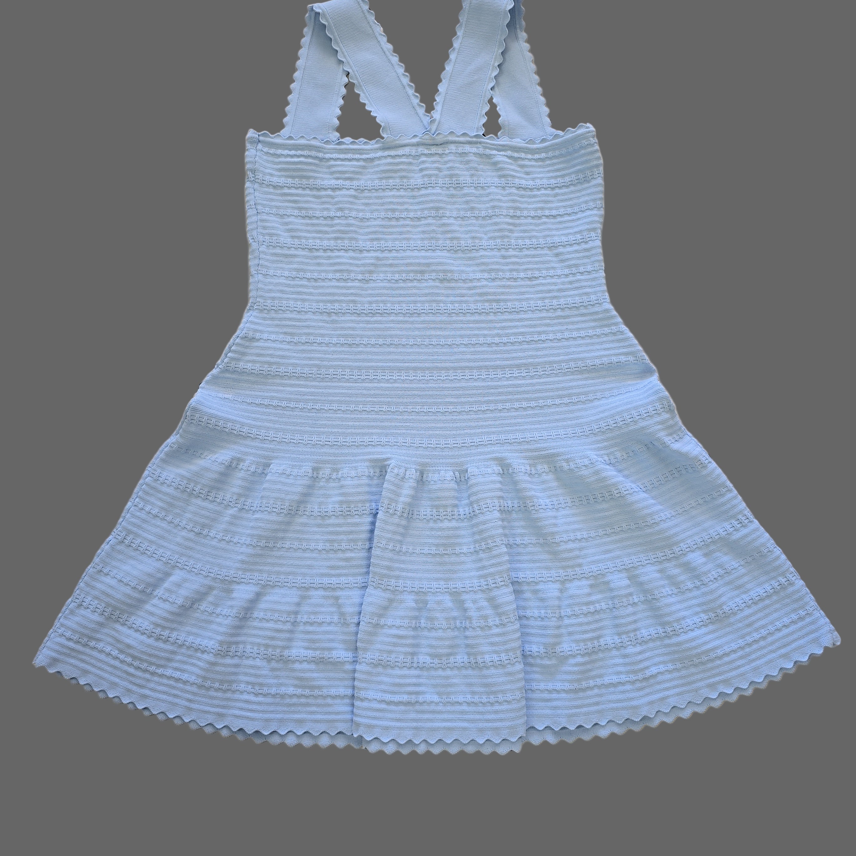 Light blue ribbed tank top with thin straps on a tiled floor.