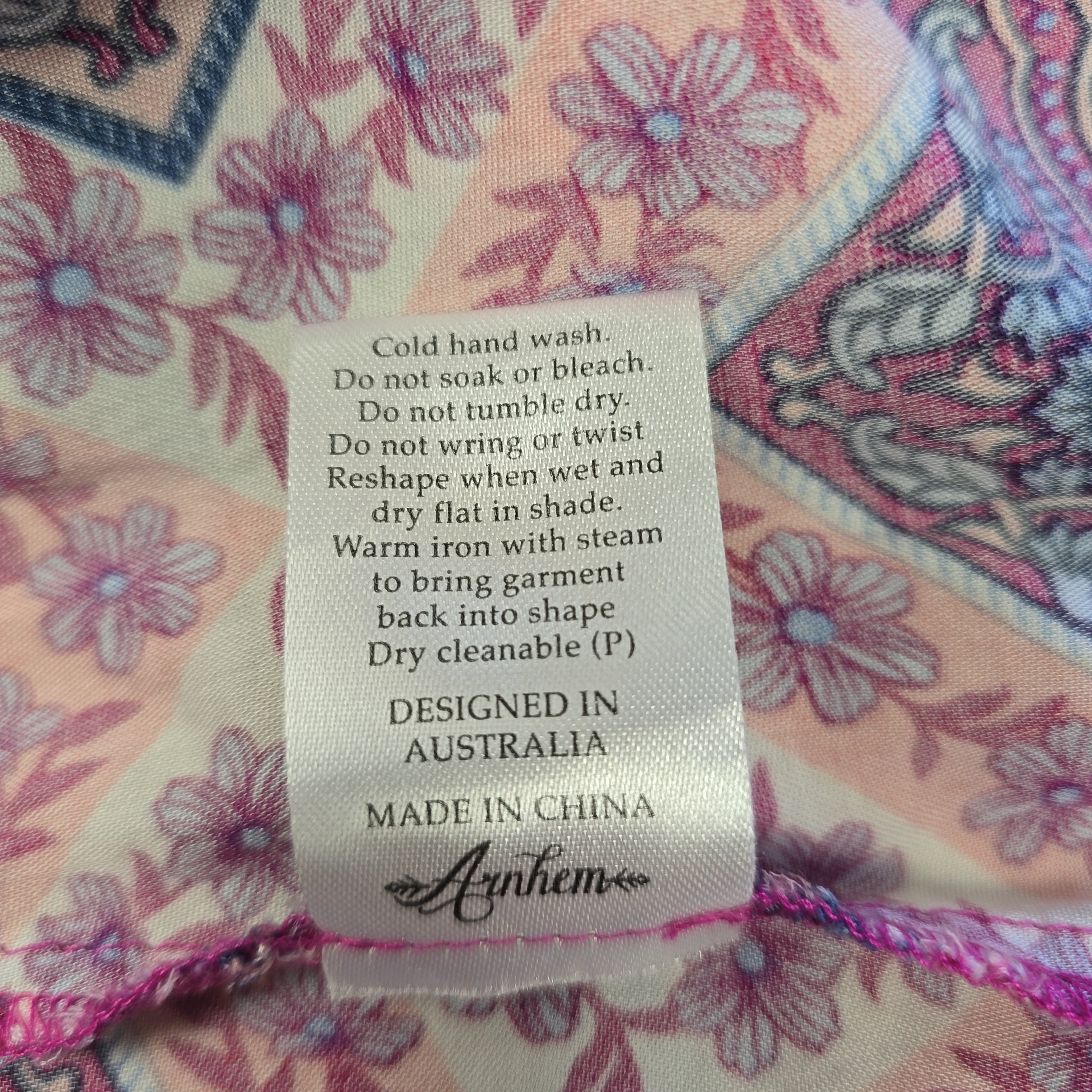 Fabric label with care instructions on a floral-patterned fabric background