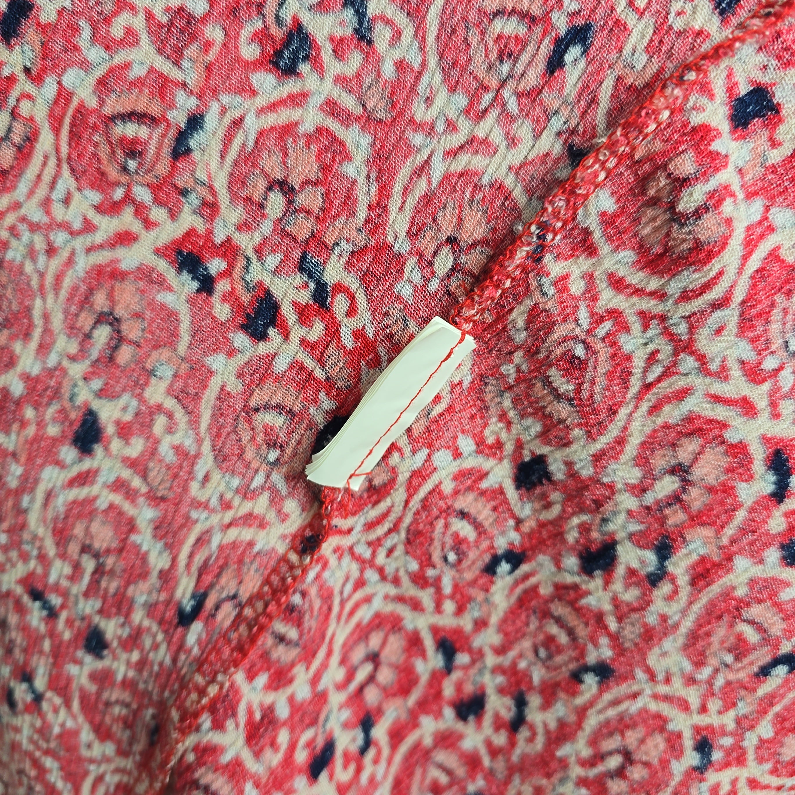 Close-up of a red patterned fabric with a white label