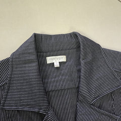 Close-up of a striped garment with a visible label on a beige background