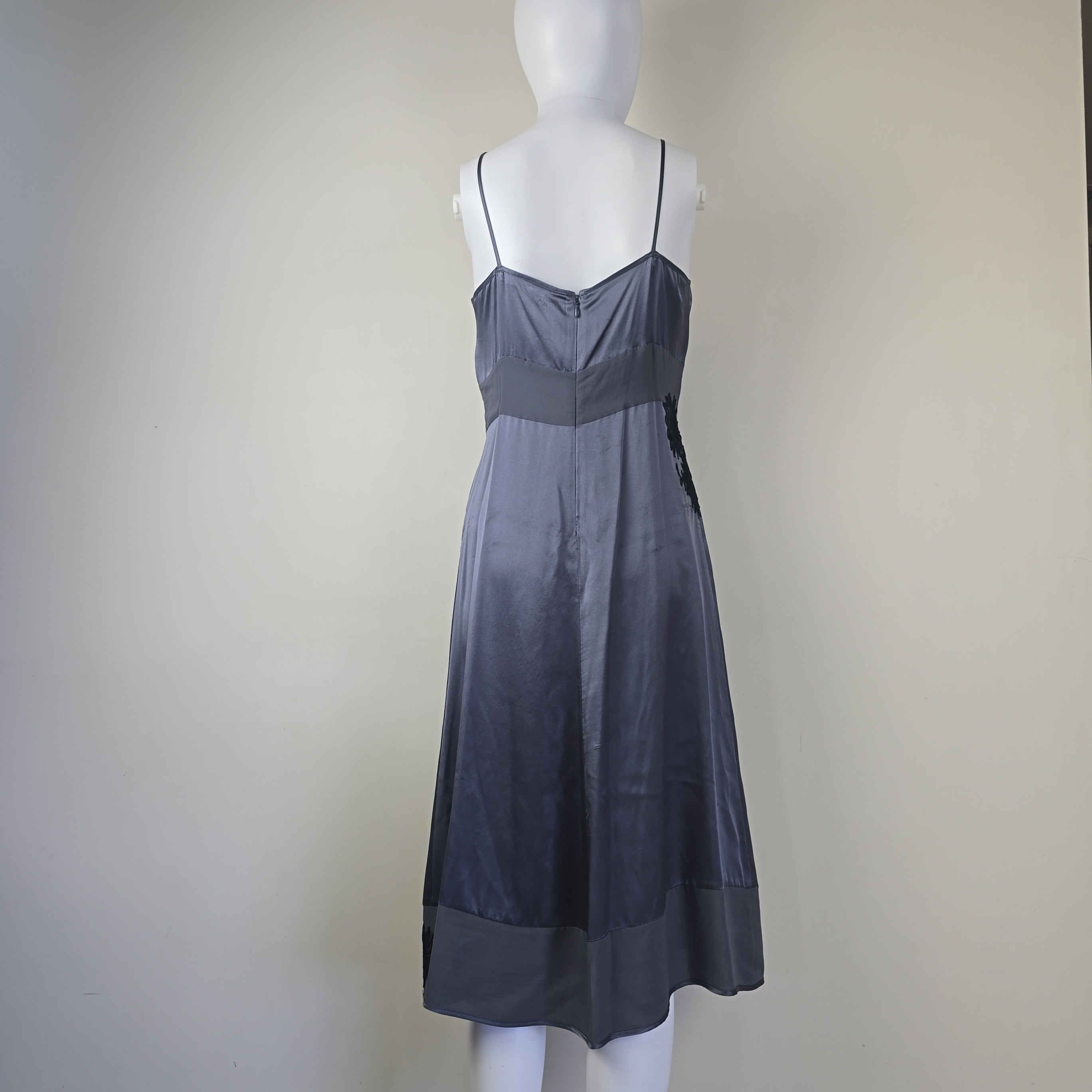 Mannequin wearing a dark gray strapless dress on a plain background