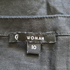 Clothing tag on a gray fabric with 'WOMAN' and size '10' printed on it.