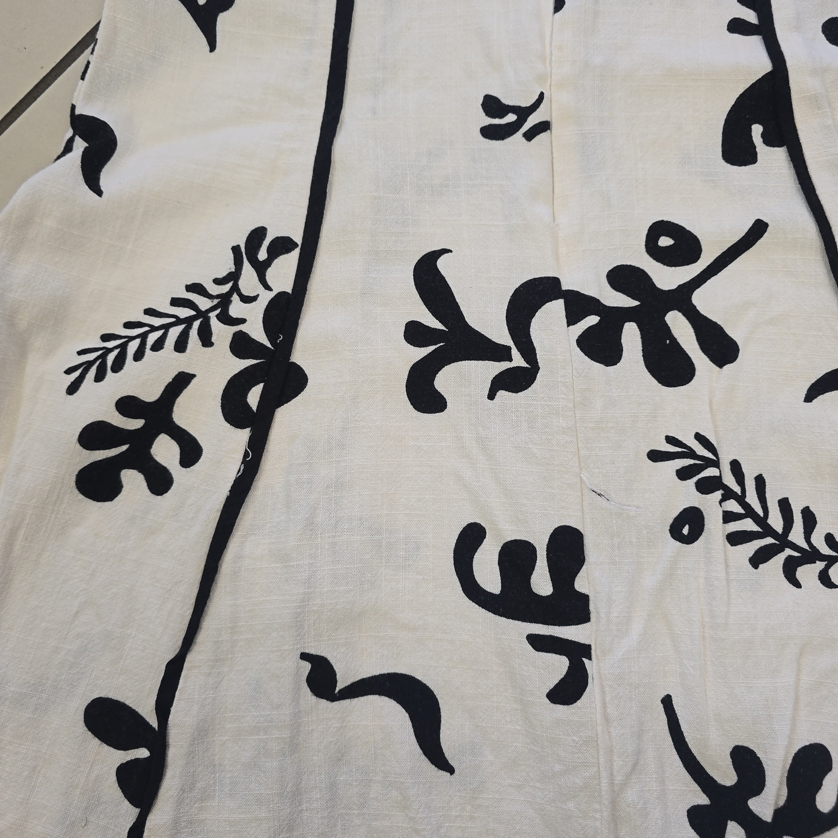 Black floral patterns on a beige fabric background