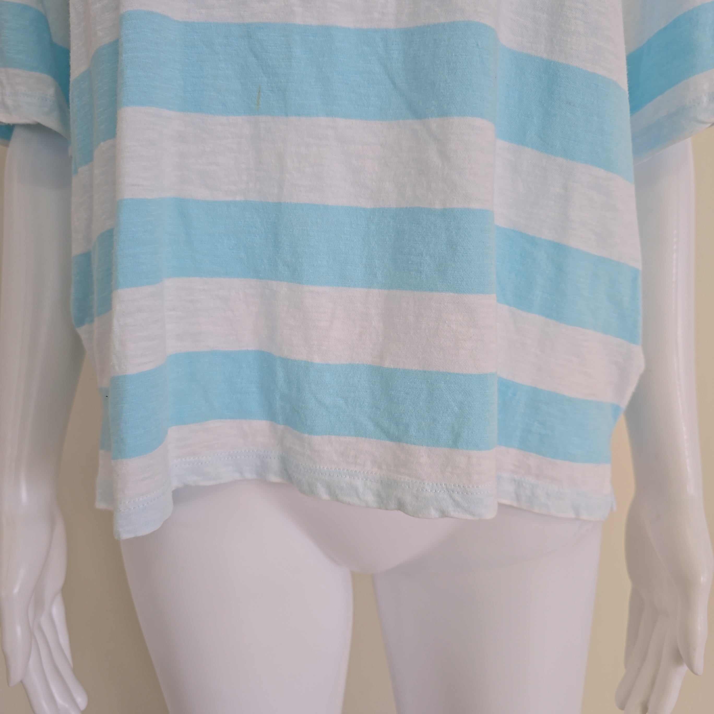 Mannequin wearing a blue and white striped top on a plain background
