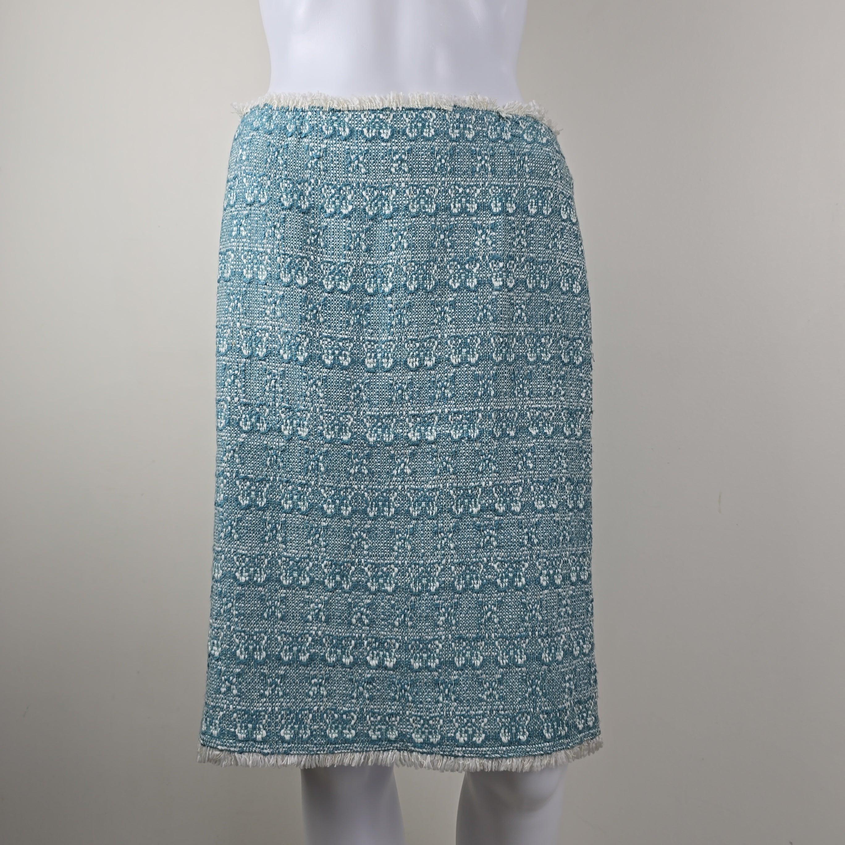 Textured blue skirt on a mannequin arm against a neutral background