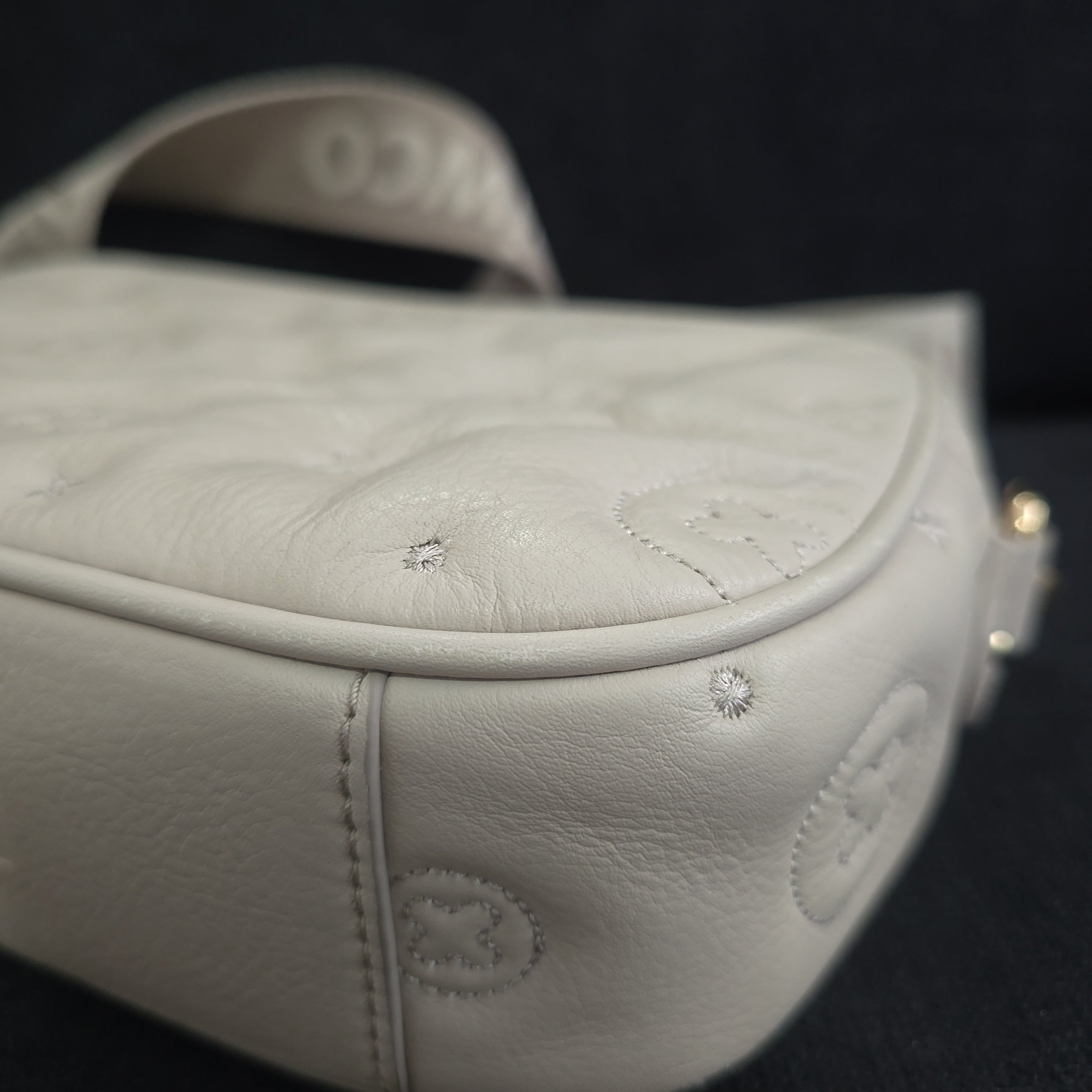 Grey shoulder bag with gold accents on a light background