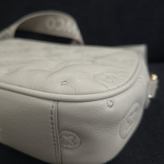 Grey shoulder bag with gold accents on a light background