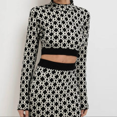 Person wearing a black and white patterned outfit on a plain background