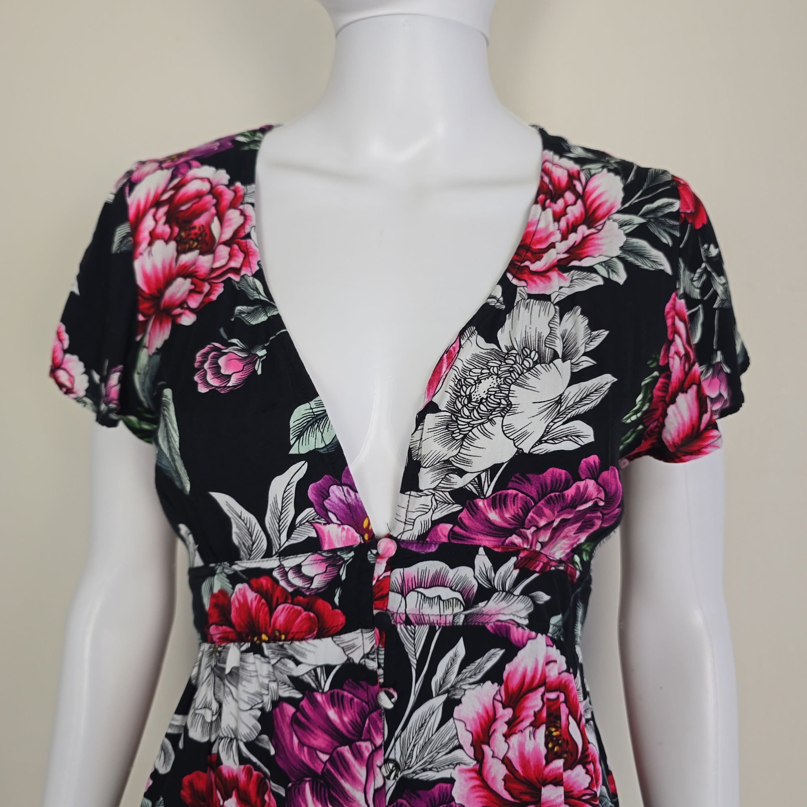 Floral patterned garment on a mannequin against a neutral background