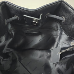 Close-up of a black leather bag with a visible brand tag.