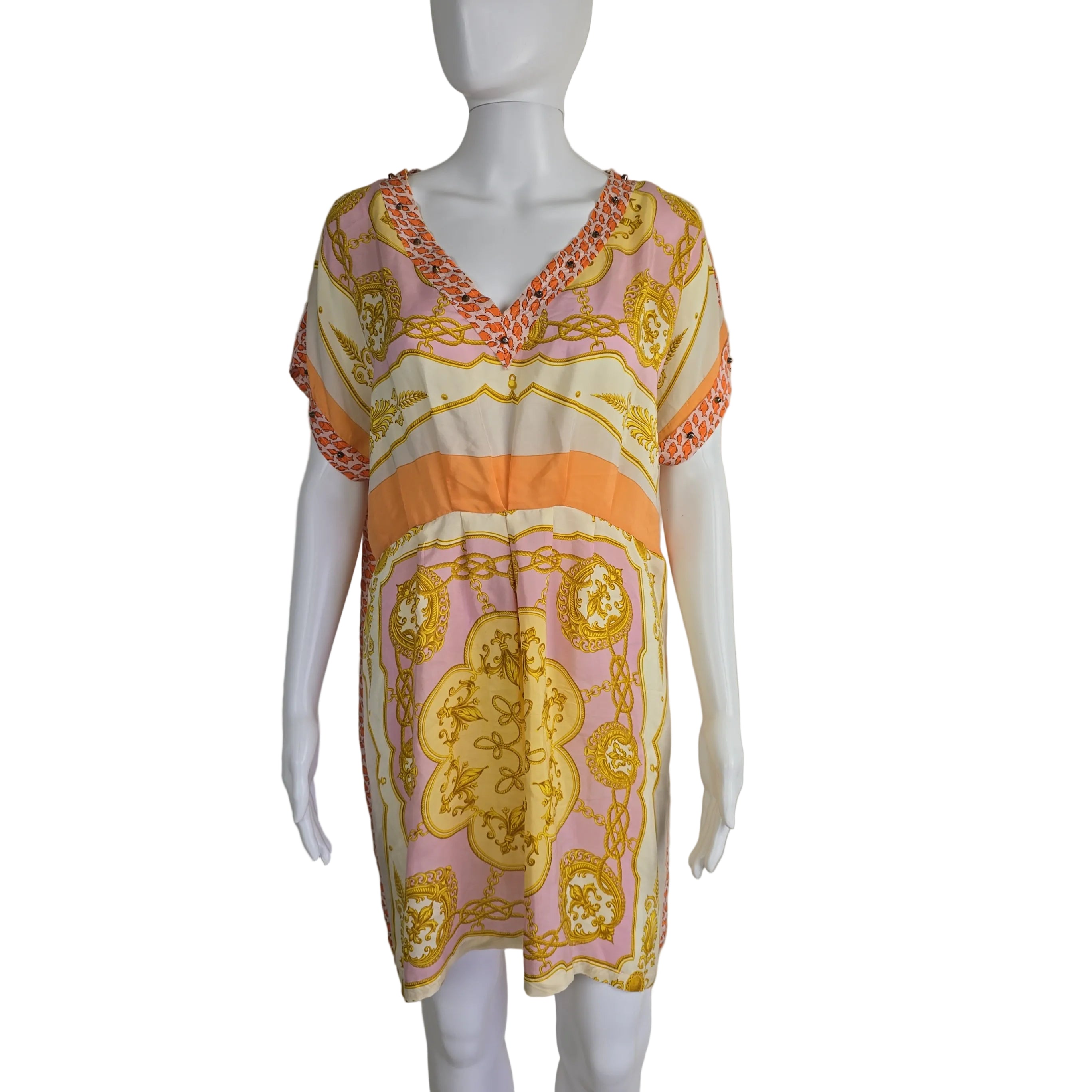 Mannequin wearing a patterned dress with pink, orange, and yellow design on a plain background