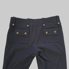 Black pants with gold buttons on a tiled floor