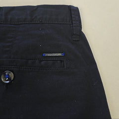 Close-up of a black pants with a blue label on a beige background