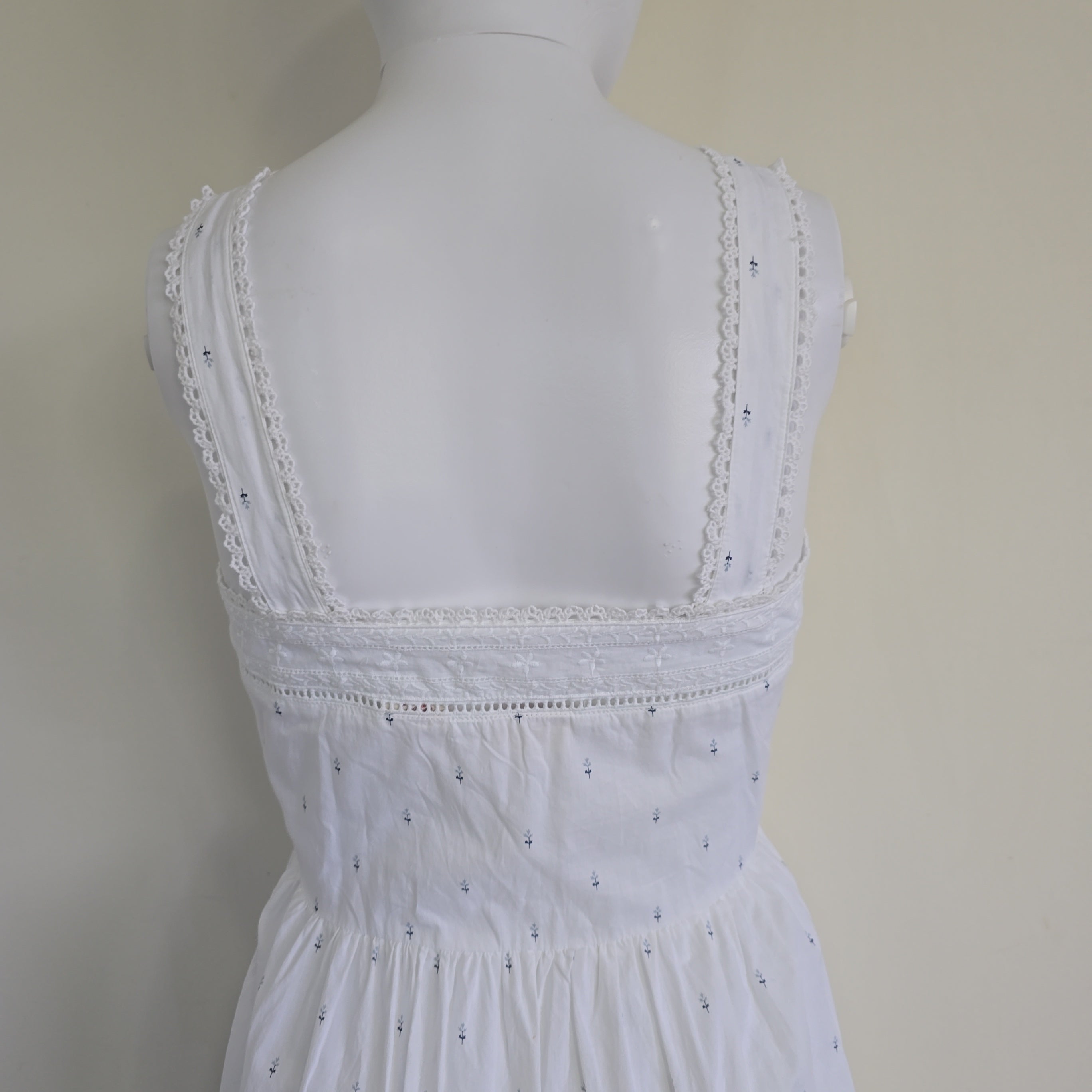White lace dress on a mannequin against a beige background